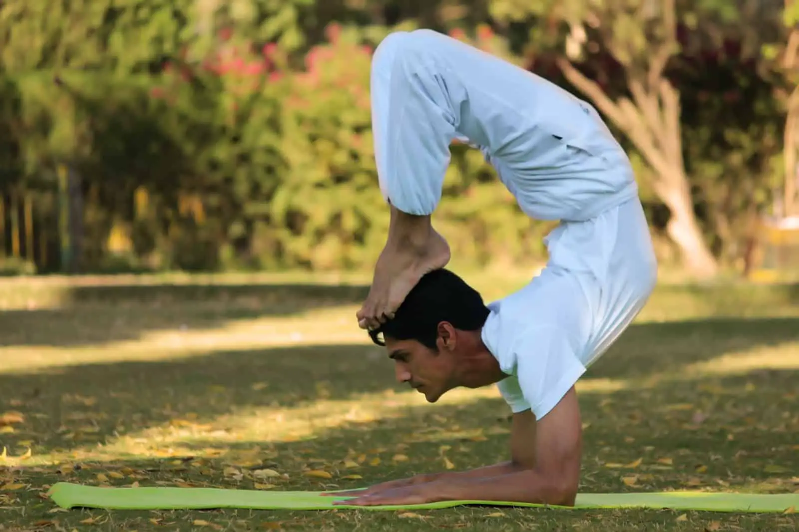 a man plays yoga with white shirt and pant